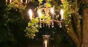 Quoi de plus romantique pour un dîner en tête à tête dans le jardin que de suspendre 2 lustres dans un arbre et d'avoir un photophore sur la table ronde !